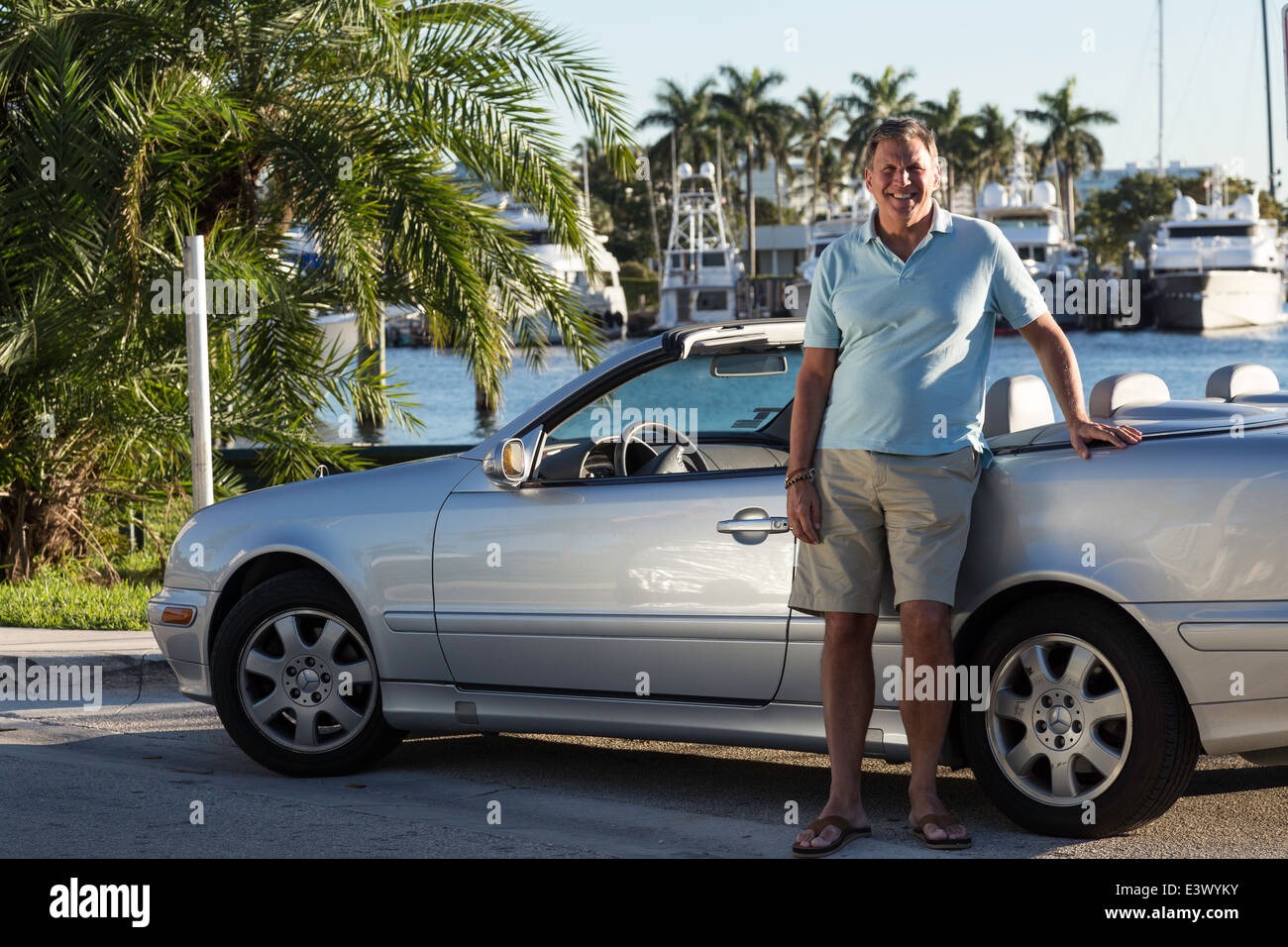 Caucasian Man debout à côté de son bateau voiture décapotable, Ft Lauderdale, FL, USA Banque D'Images