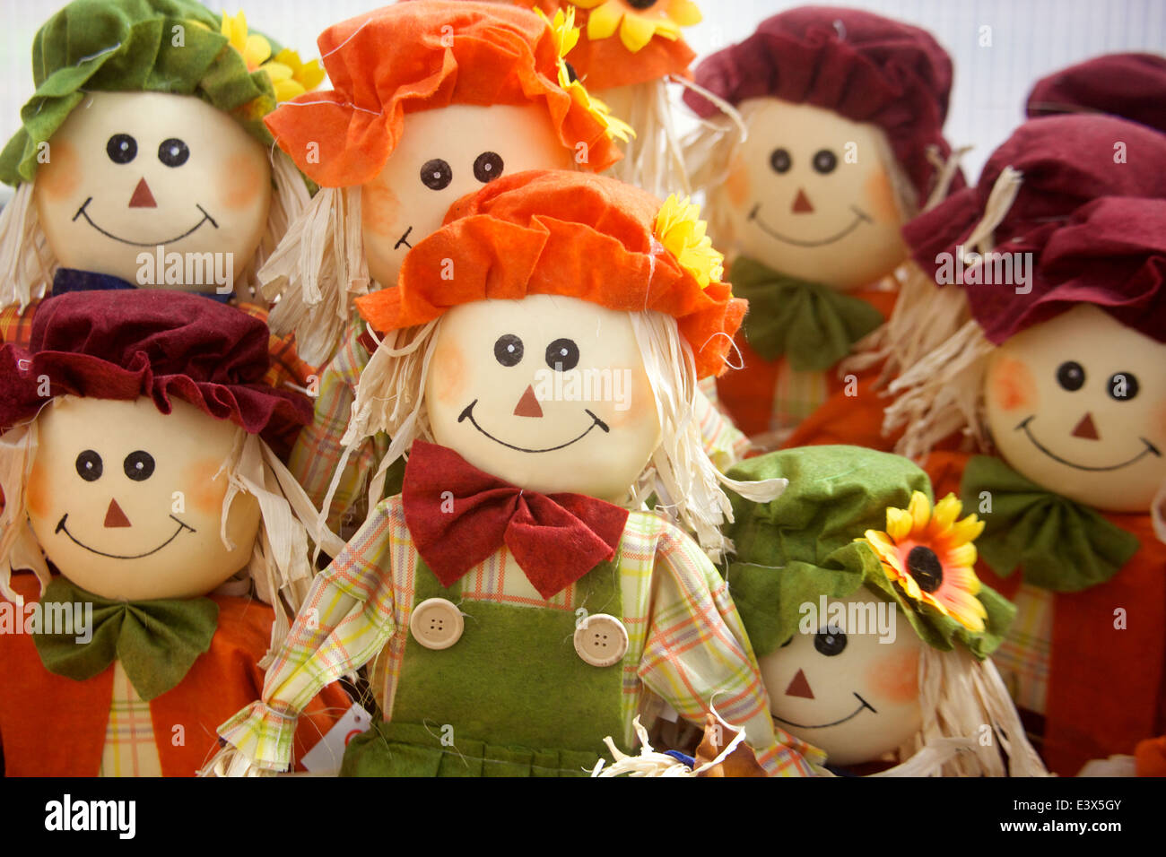 Rangée d'épouvantails de paille avec des bonnets de couleur. Banque D'Images