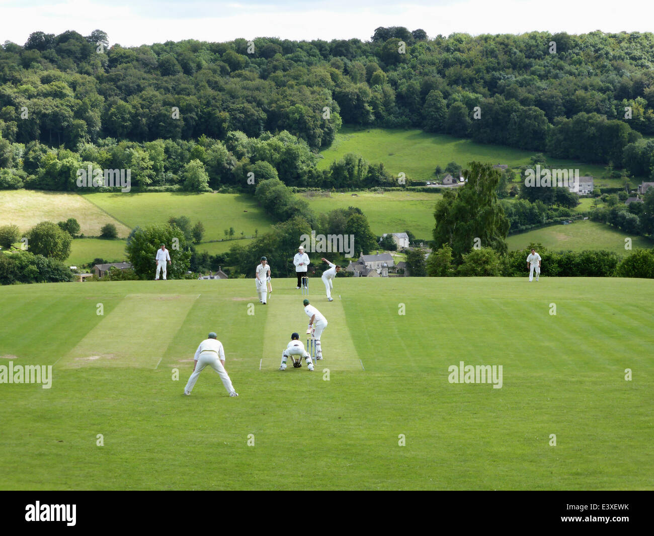 Sheepscombe, Gloucestershire, Royaume-Uni. 29 juin 2014. Une partie de cricket est joué entre Sheepscombe Slad et clubs de cricket dans le cadre de la Laurie Lee centenaire à Sheepscombe, Gloucestershire, Royaume-Uni, dimanche 29 juin 2014. Un banc avec vue sur le terrain qu'il possédait était autrefois dédié à Lee et il est inscrit avec un commentaire il a fait allusion à la forme du terrain : il a comparé ce motif d'un poney est de retour. Ancienne Angleterre cricketer Mike Gatting a assisté à l'événement avec son épouse Kathy Lee et de sa fille Jessy Lee. Credit : Deborah Roberts/Alamy Live News Banque D'Images