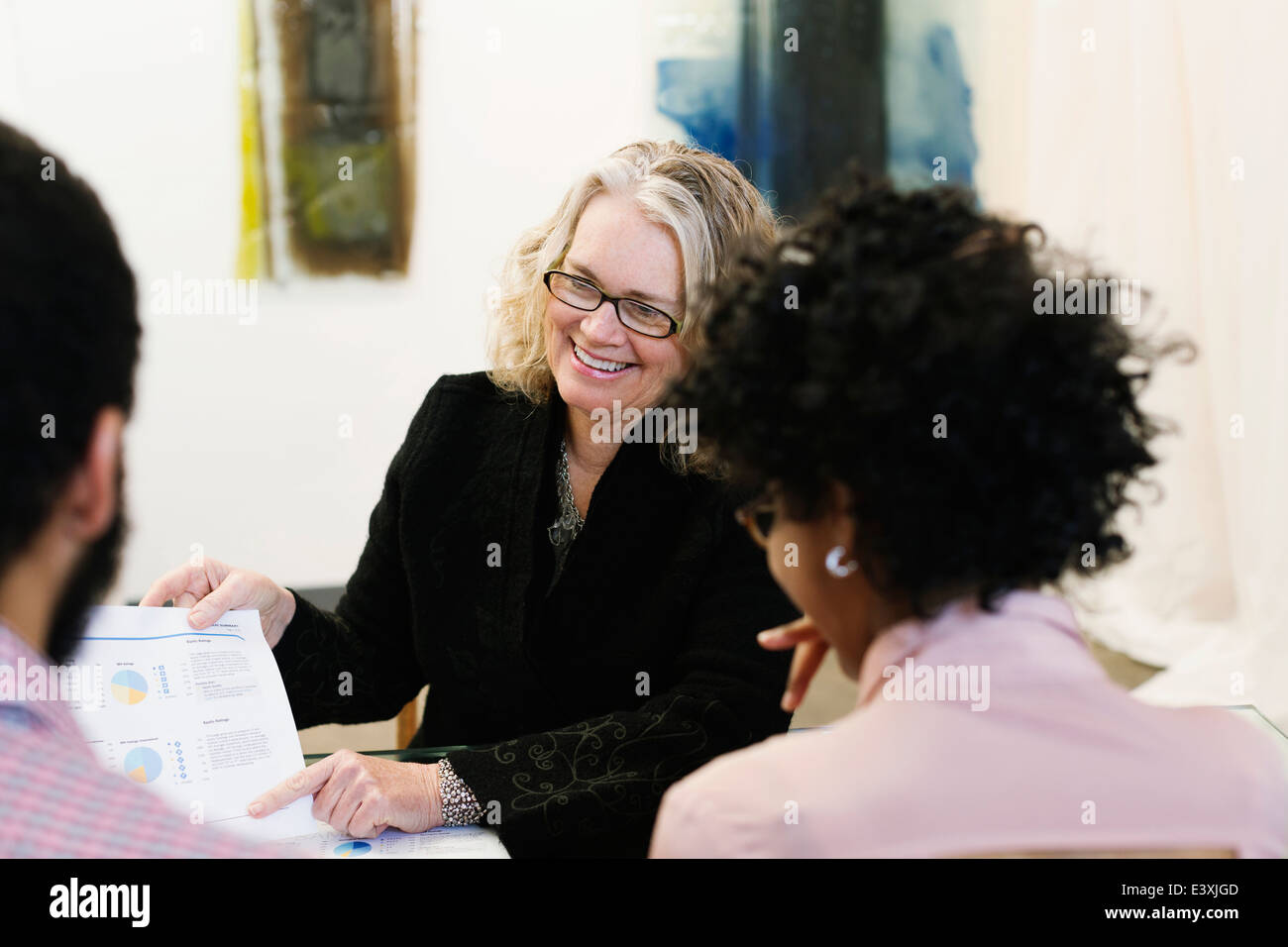 Businesswoman talking to young couple Banque D'Images