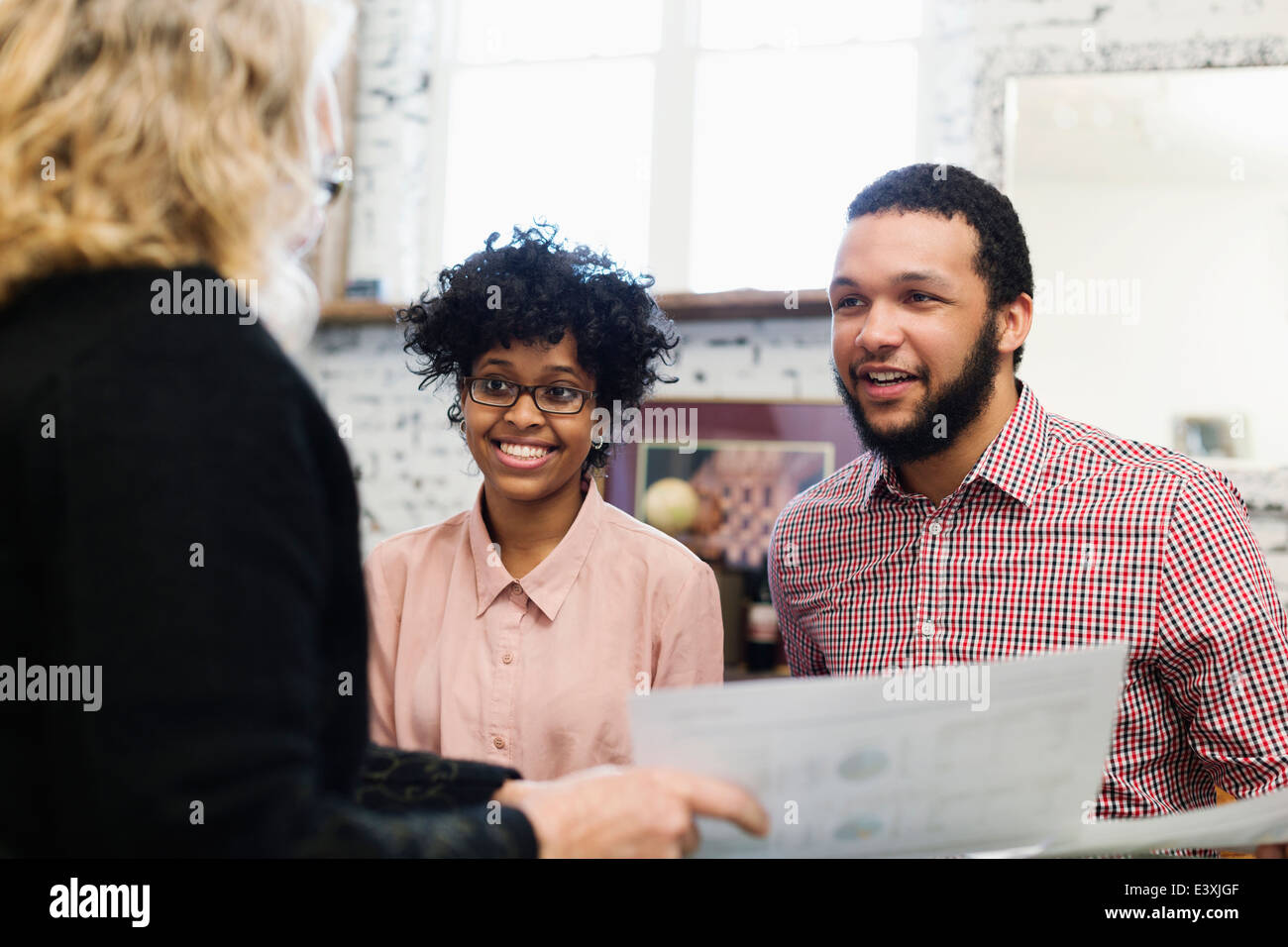 Businesswoman talking to young couple Banque D'Images