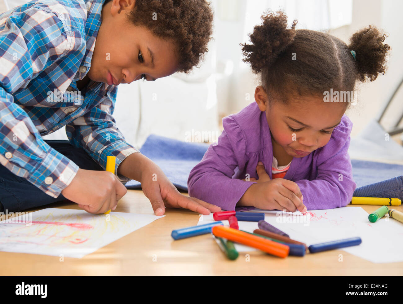 Les enfants noirs coloration sur plancher du salon Banque D'Images