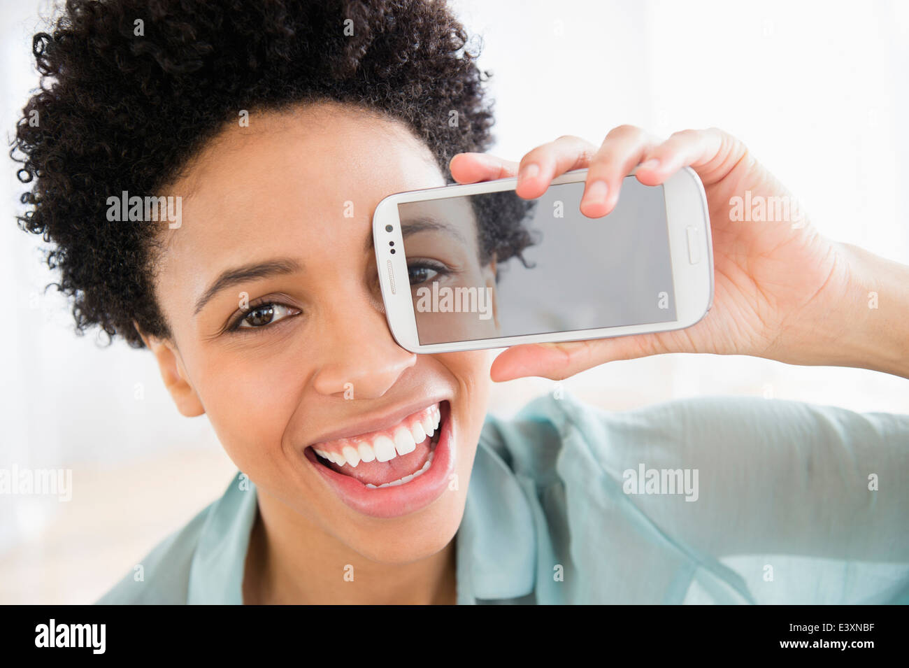 Black woman holding photo de son oeil sur son visage Banque D'Images