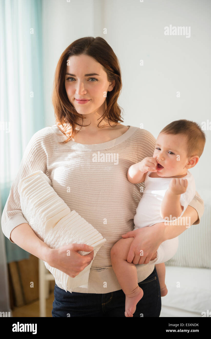 Mother holding baby et pile de couches Banque D'Images