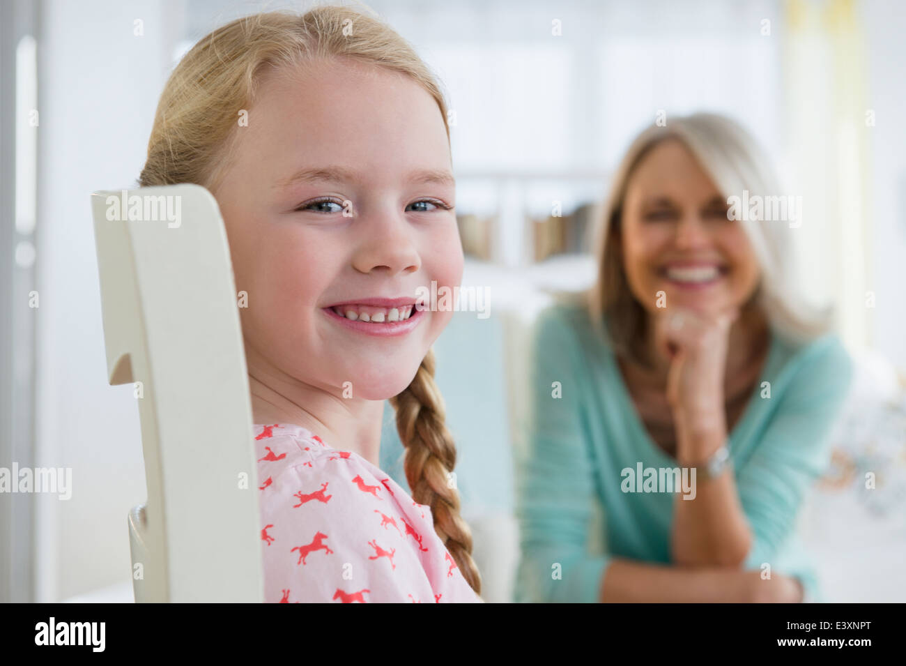 Caucasian girl smiling in chair Banque D'Images