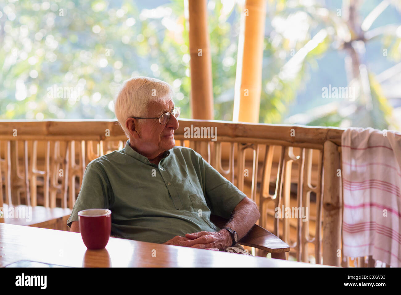 Caucasian man ayant tasse de café en treehouse Banque D'Images