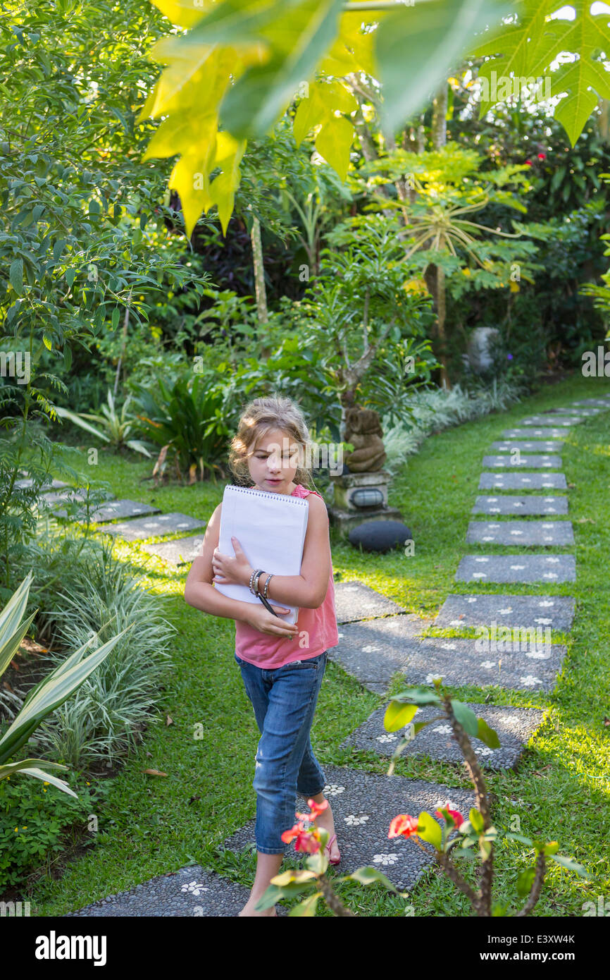 Caucasian girl with notebook in backyard Banque D'Images