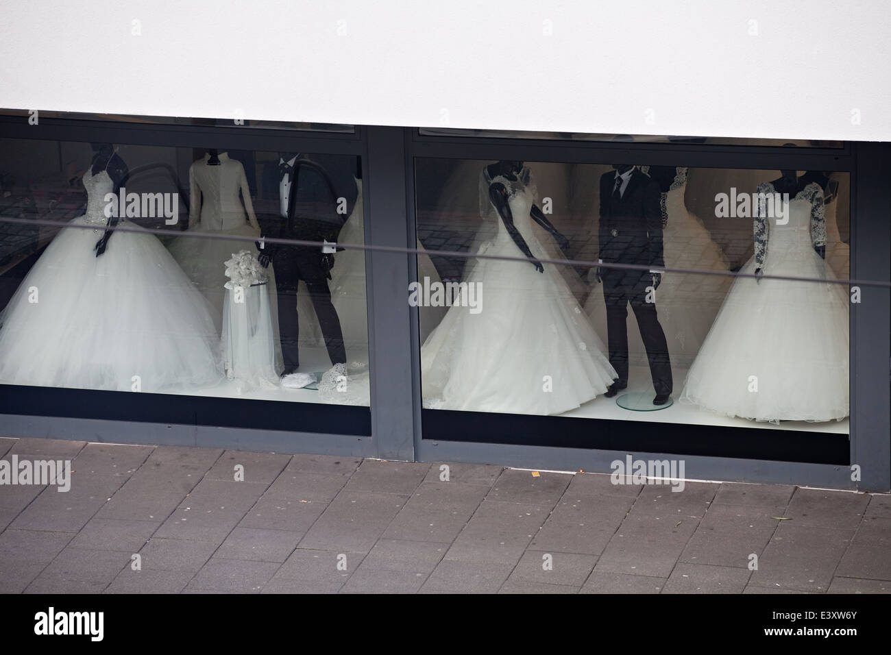 Vitrine de salon du mariage avec blanc mariée robes et costumes noirs Banque D'Images