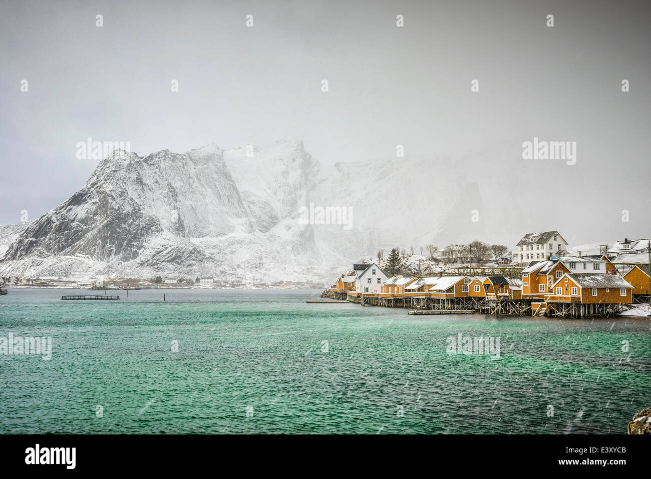 Montagnes enneigées surplombant la côte rocheuse, Reine, îles Lofoten, Norvège Banque D'Images