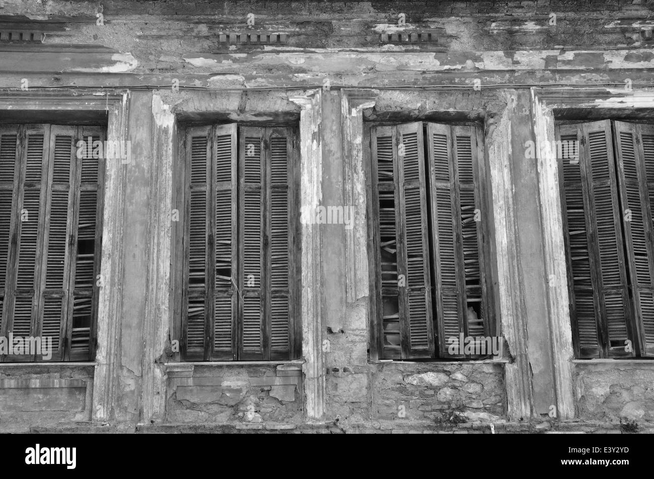 Volets en bois cassée et texturé mur d'une maison abandonnée. La dégradation du milieu urbain en noir et blanc. Banque D'Images