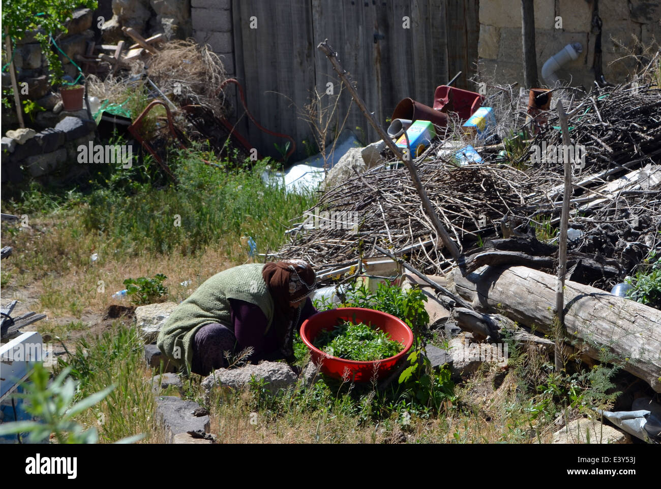 Une dame âgée tend la production de certains logement délabré à Capadoccia.Centre de la Turquie. Banque D'Images