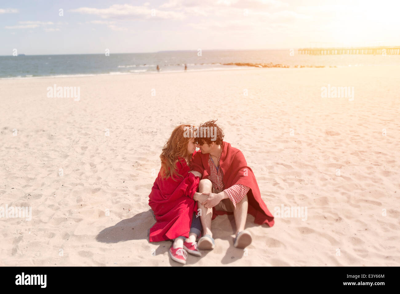 Couple romantique enveloppés dans des couvertures à beach Banque D'Images