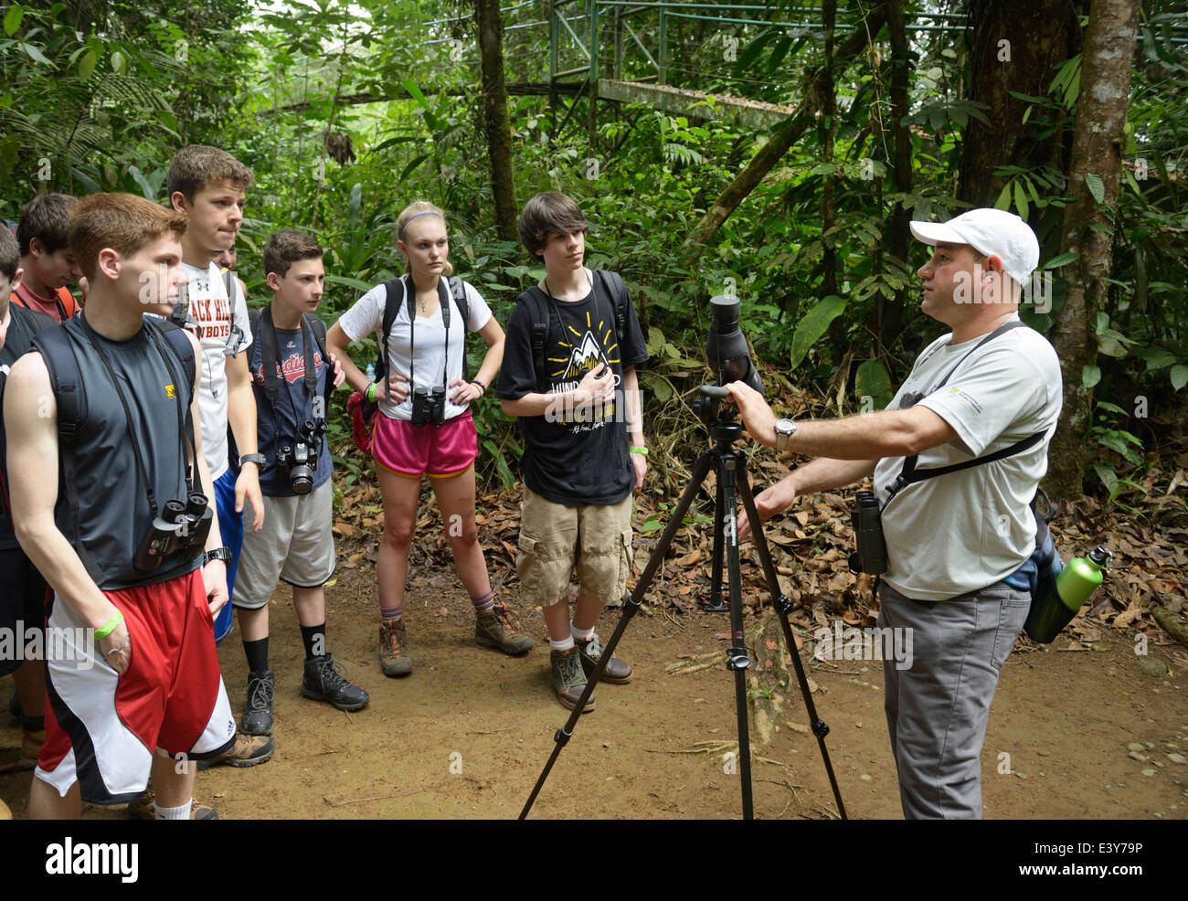 Groupe d'écotouristes adolescentes sur une écologie de la forêt tropicale à pied, Selva Verde, Costa Rica. Leur guide est un naturaliste du Costa Rica Banque D'Images