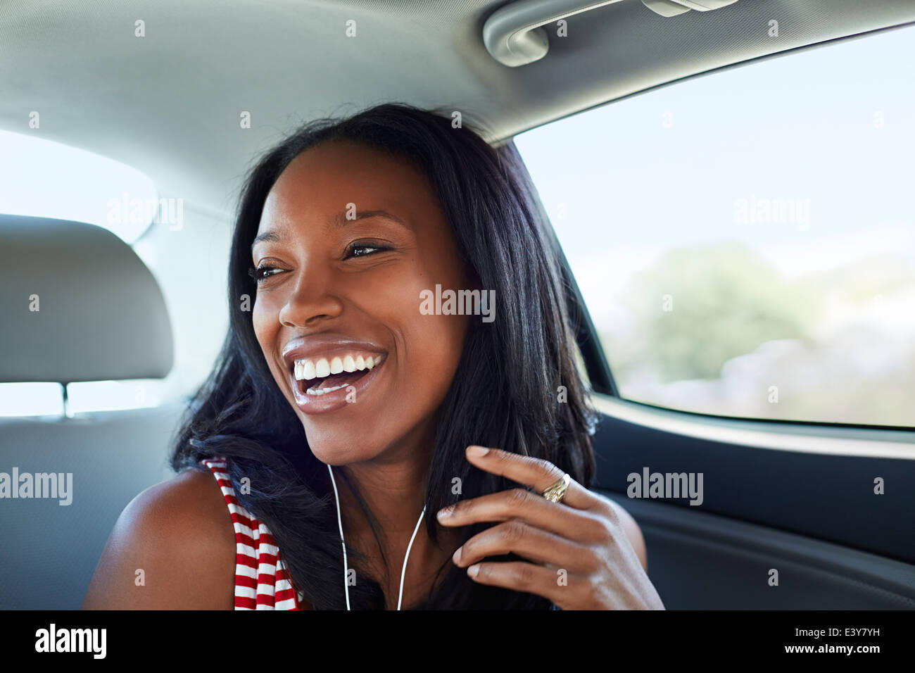 Jeune femme en riant voiture backseat Banque D'Images