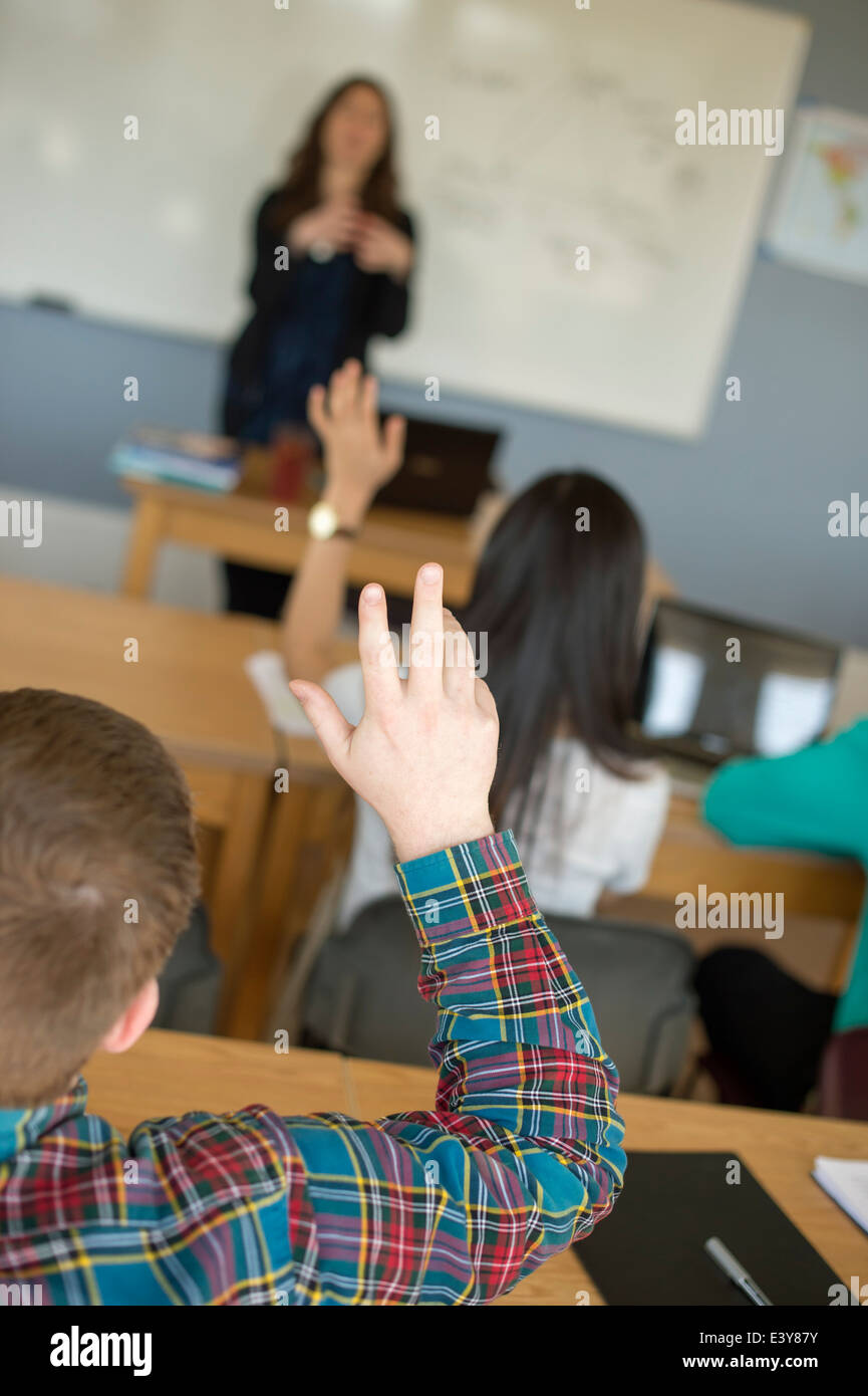 Avec des élèves en classe les mains posées Banque D'Images