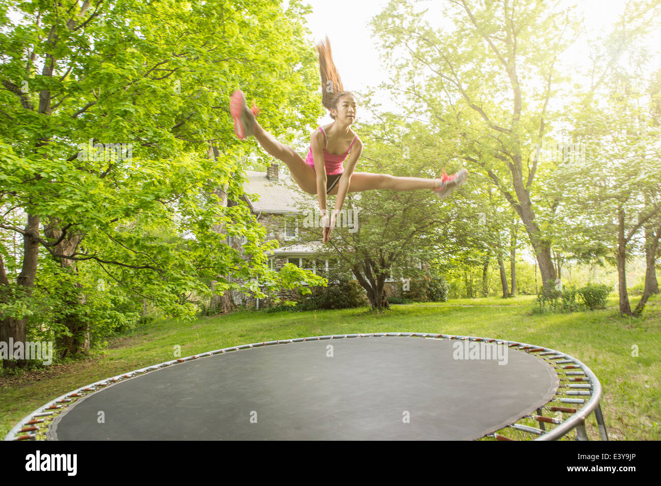 Teenage girl jumping on trampoline, à l'extérieur Photo Stock - Alamy
