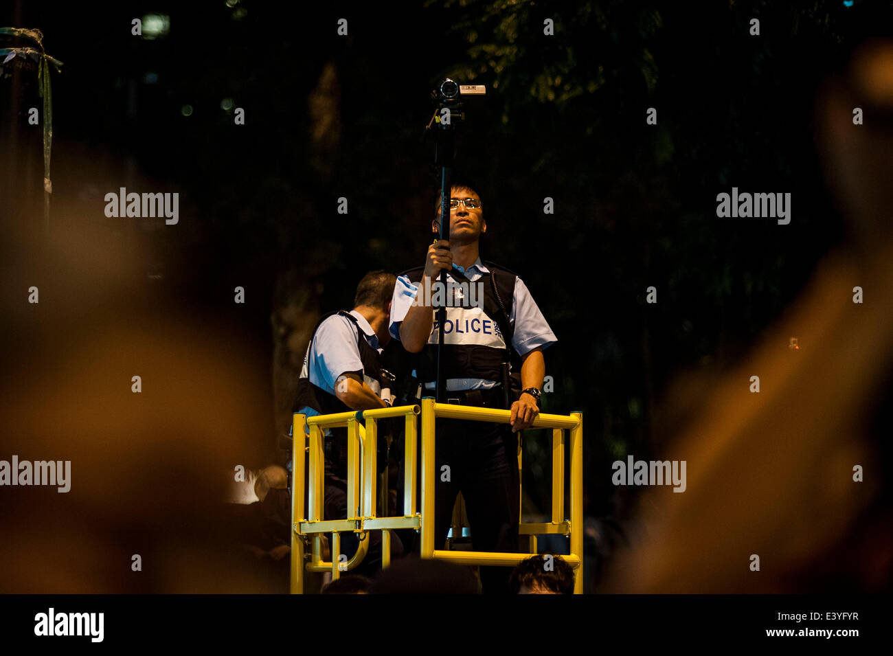 Hong Kong. 1er juillet 2014. Films policier que de manifestants s'asseoir dans une rue du district central après une manifestation pro-démocratie à la recherche d'une plus grande démocratie à Hong Kong le 01 juillet 2014 que la frustration se développe sur l'influence de Pékin sur la ville. Credit : Xaume Olleros/Alamy Live News Banque D'Images