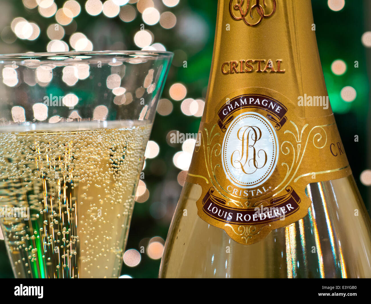Bouteille DE CHAMPAGNE CRISTAL et verre de champagne Louis Roederer Cristal fraîchement déversé, avec lumières étincelantes en arrière-plan Banque D'Images