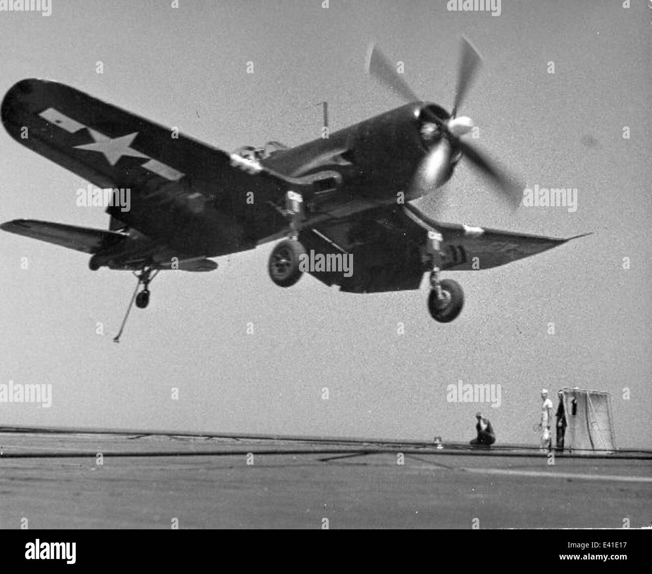 Cette photographie montre un Vought F4U-4 Corsair atterrissant sur le porte-avions USS Boxer (CVB-42), démontrant les opérations de porte-avions et les techniques de l'aviation navale au milieu du XXe siècle. Banque D'Images