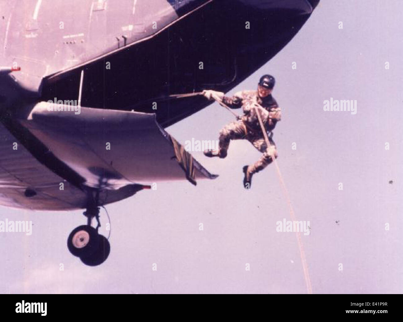 Un SEAL DE l'US Navy sort d'un hélicoptère CH-46 Sea Knight via une corde, démontrant les tactiques militaires spécialisées utilisées dans les opérations navales. Banque D'Images