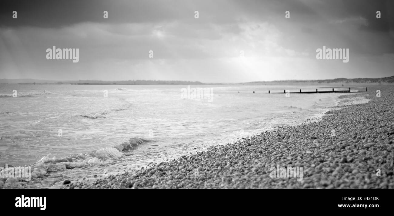 Une plage de galets de la mer en noir et blanc Banque D'Images