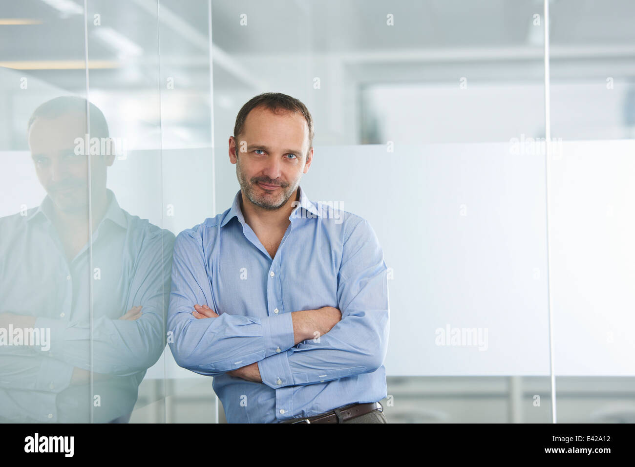 Businessman leaning against wall réfléchissant Banque D'Images