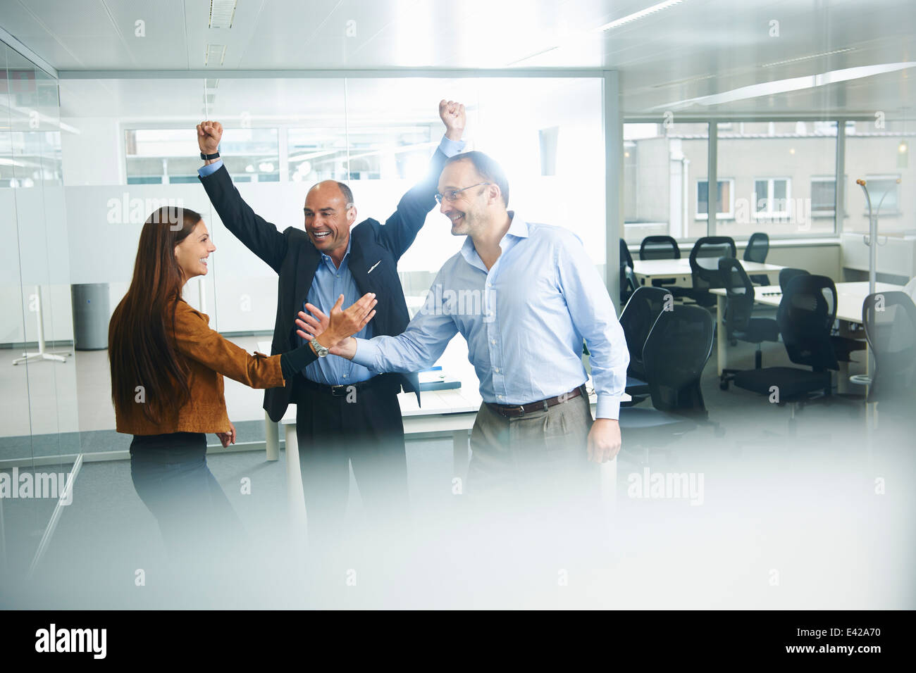 Businesspeople cheering in office Banque D'Images