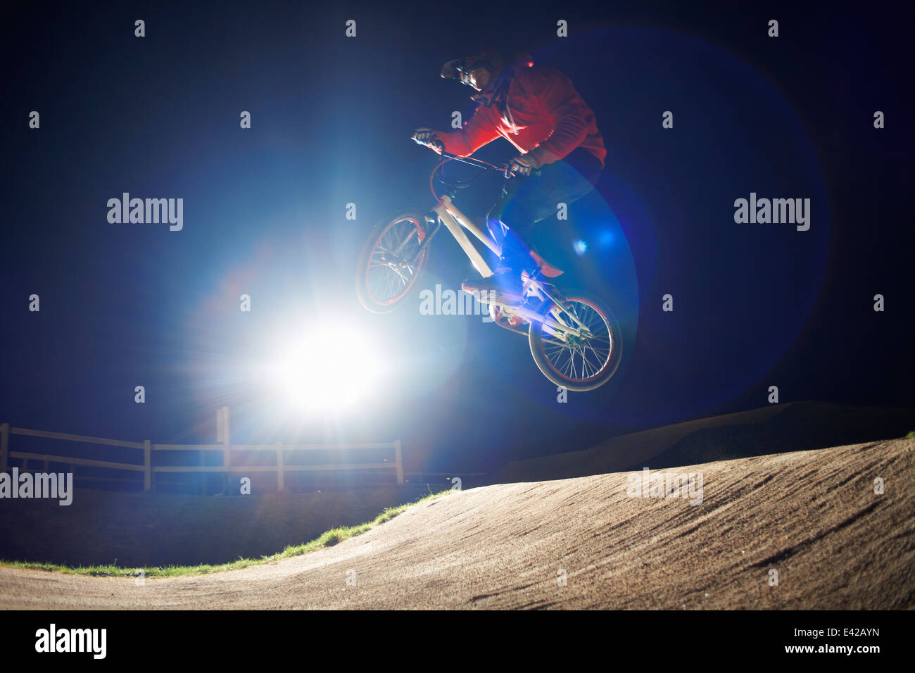 Le BMX-cyclist jumps sa moto dans l'obscurité. Banque D'Images