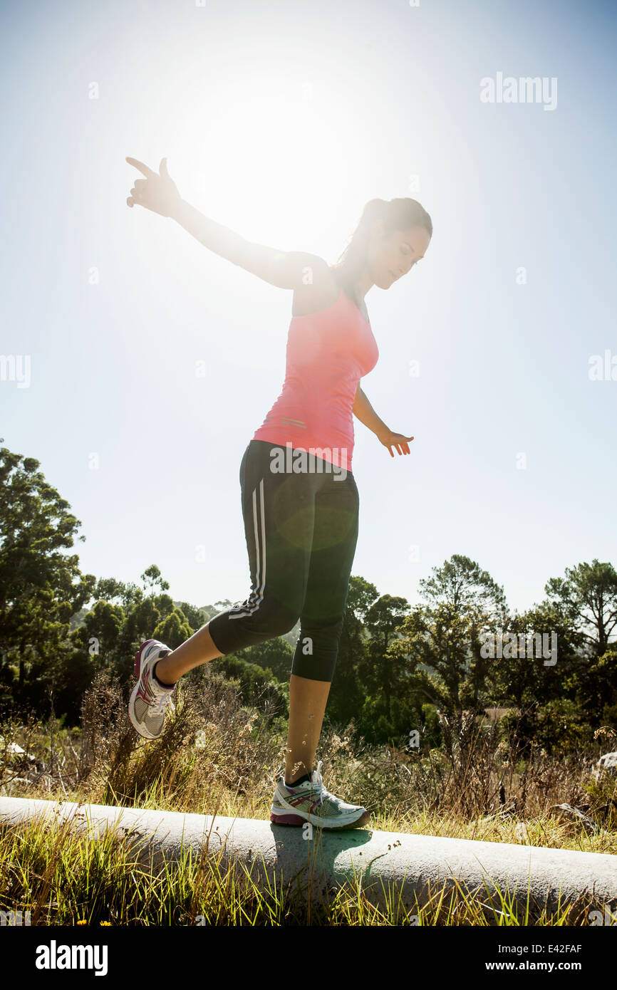 Female jogger sur le tuyau d'équilibrage Banque D'Images