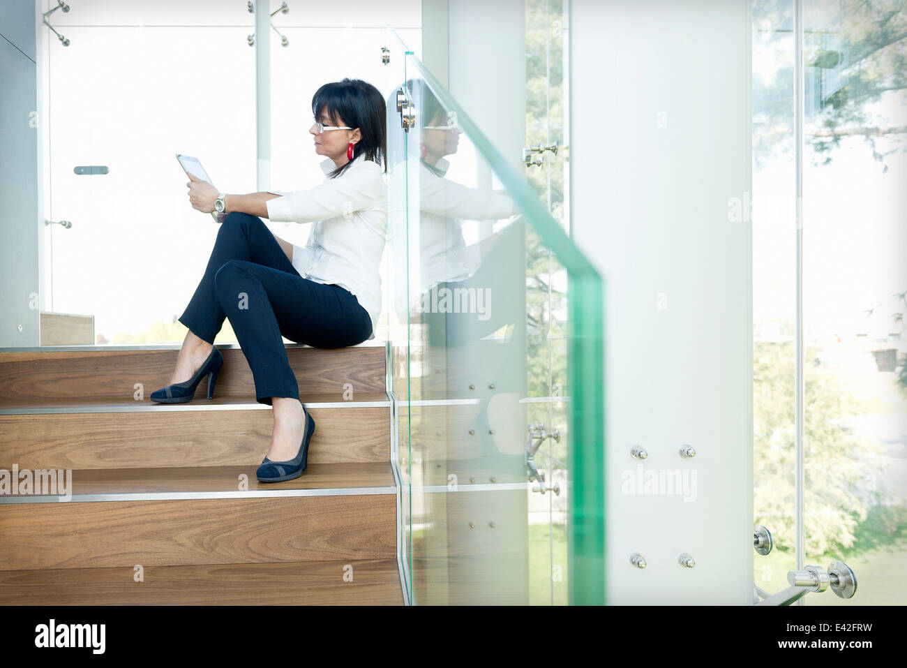 Businesswoman using digital tablet on steps Banque D'Images