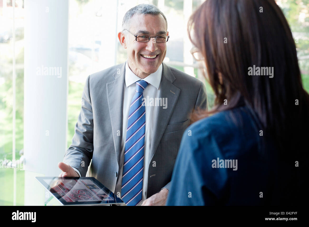 Businessman and woman using digital tablet Banque D'Images