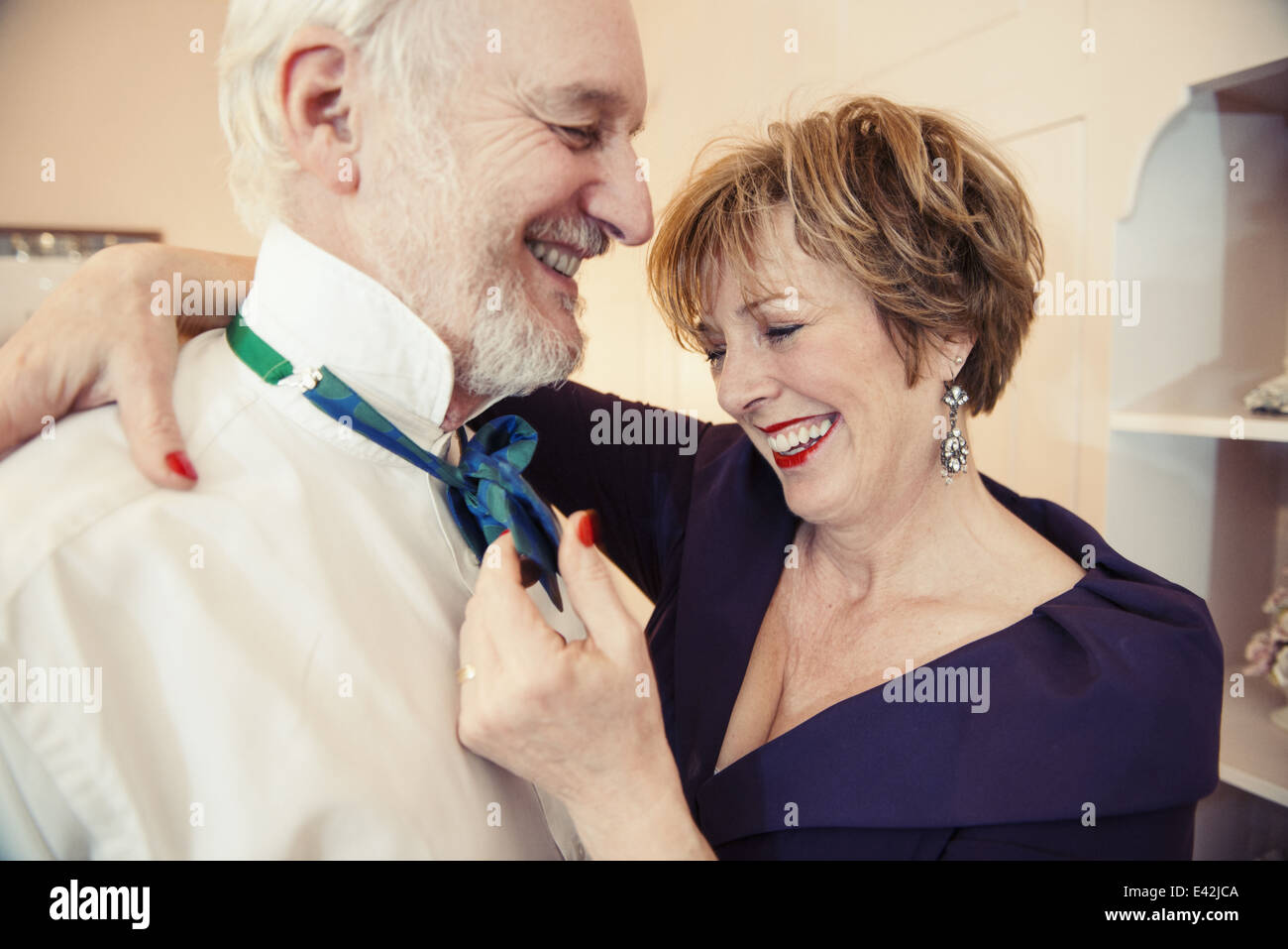 Young woman putting Bow tie sur man Banque D'Images