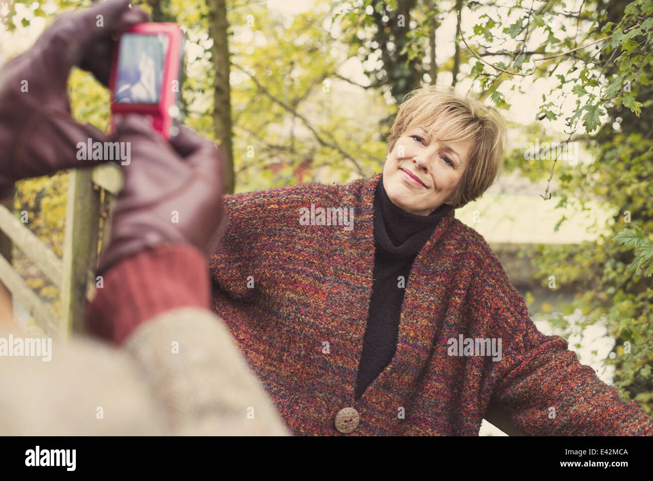L'homme de prendre la photo d'une femme on camera phone Banque D'Images