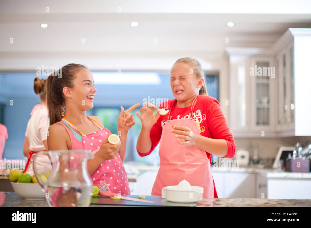 Deux adolescentes citrons aigres dégustation dans la cuisine Banque D'Images