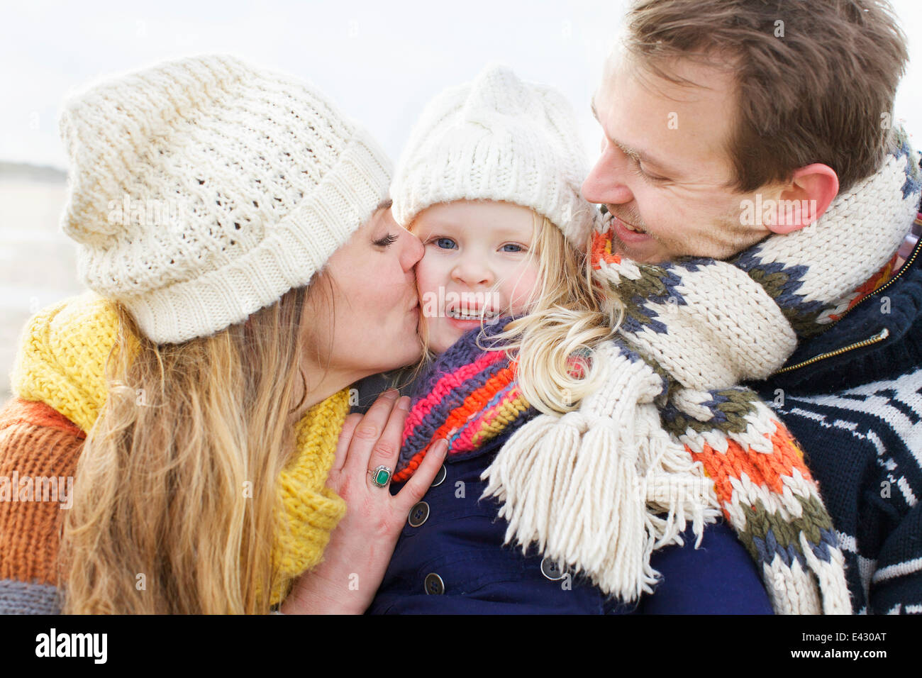 Young parents embrassant leurs fille sur la joue à l'autre Banque D'Images