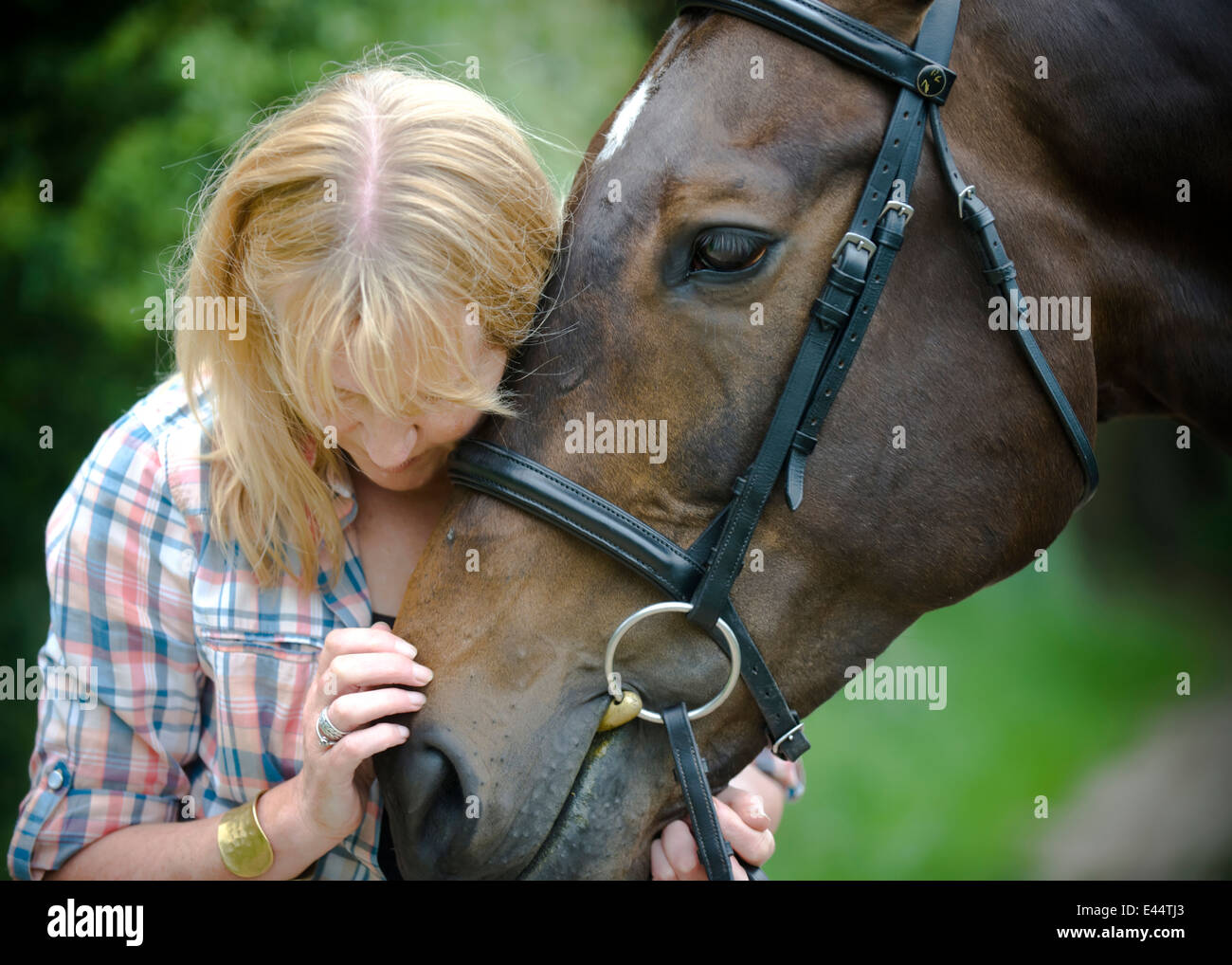 Femme plus âgée avec son cheval pur-sang Banque D'Images