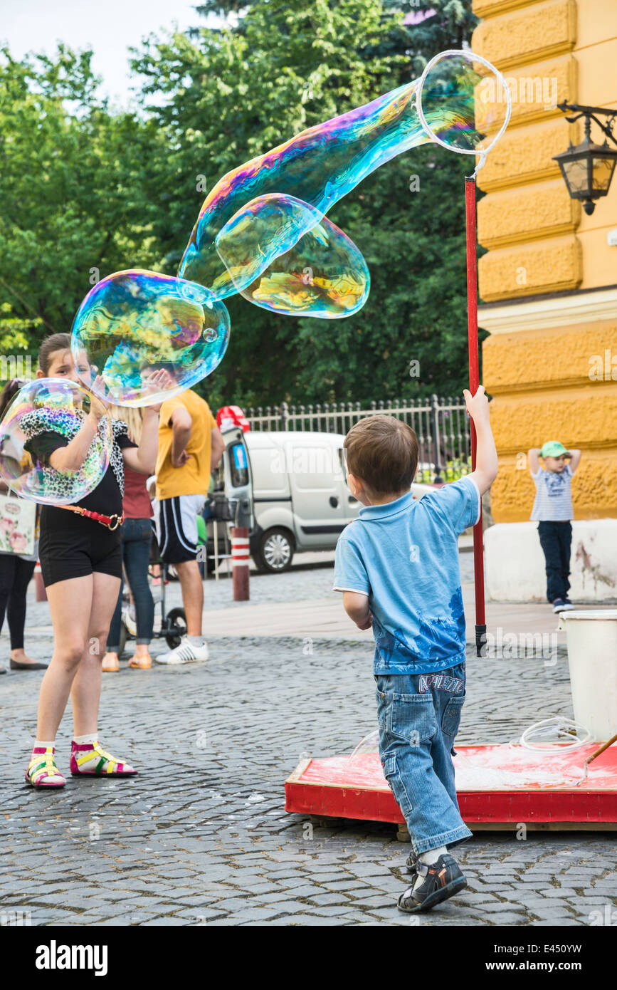 Jeune garçon faisant des bulles à Olha Kobylianska Street zone piétonne à Tchernivtsi, Ukraine, région de Bucovine Banque D'Images