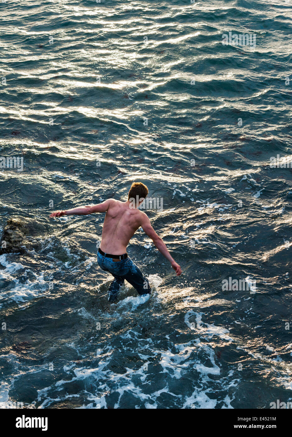 L'homme nage dans les eaux agitées. Banque D'Images