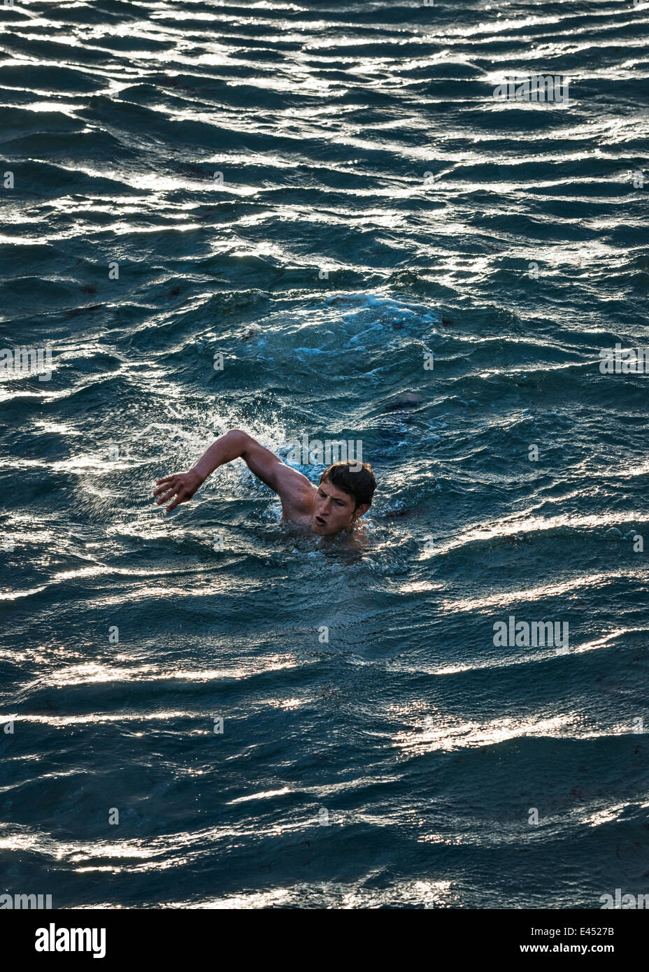 L'homme nage dans les eaux agitées. Banque D'Images