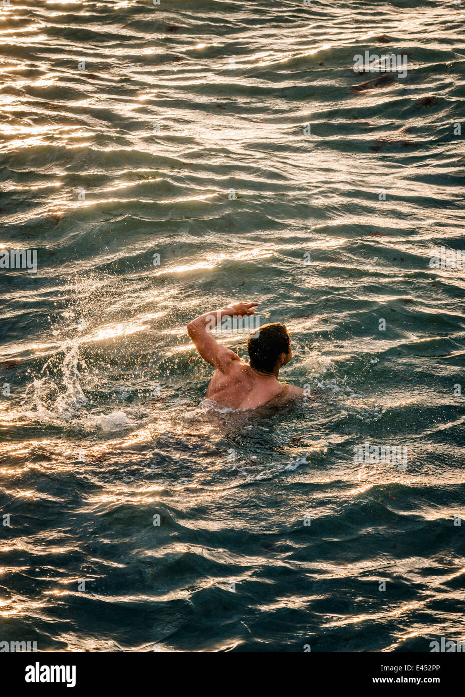 L'homme nage dans les eaux agitées. Banque D'Images