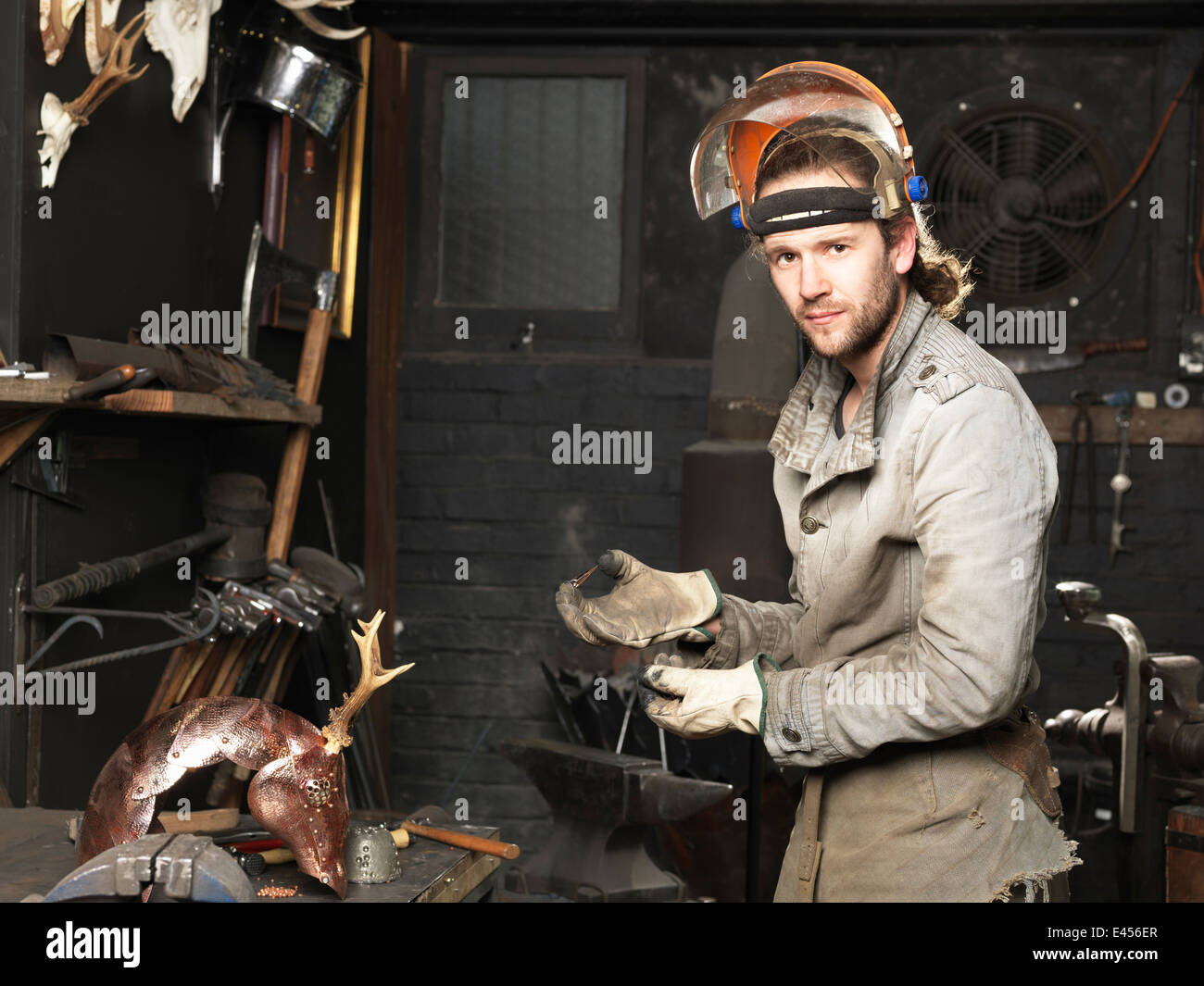 Portrait de forgeron avec un clou de cuivre dans l'atelier Banque D'Images