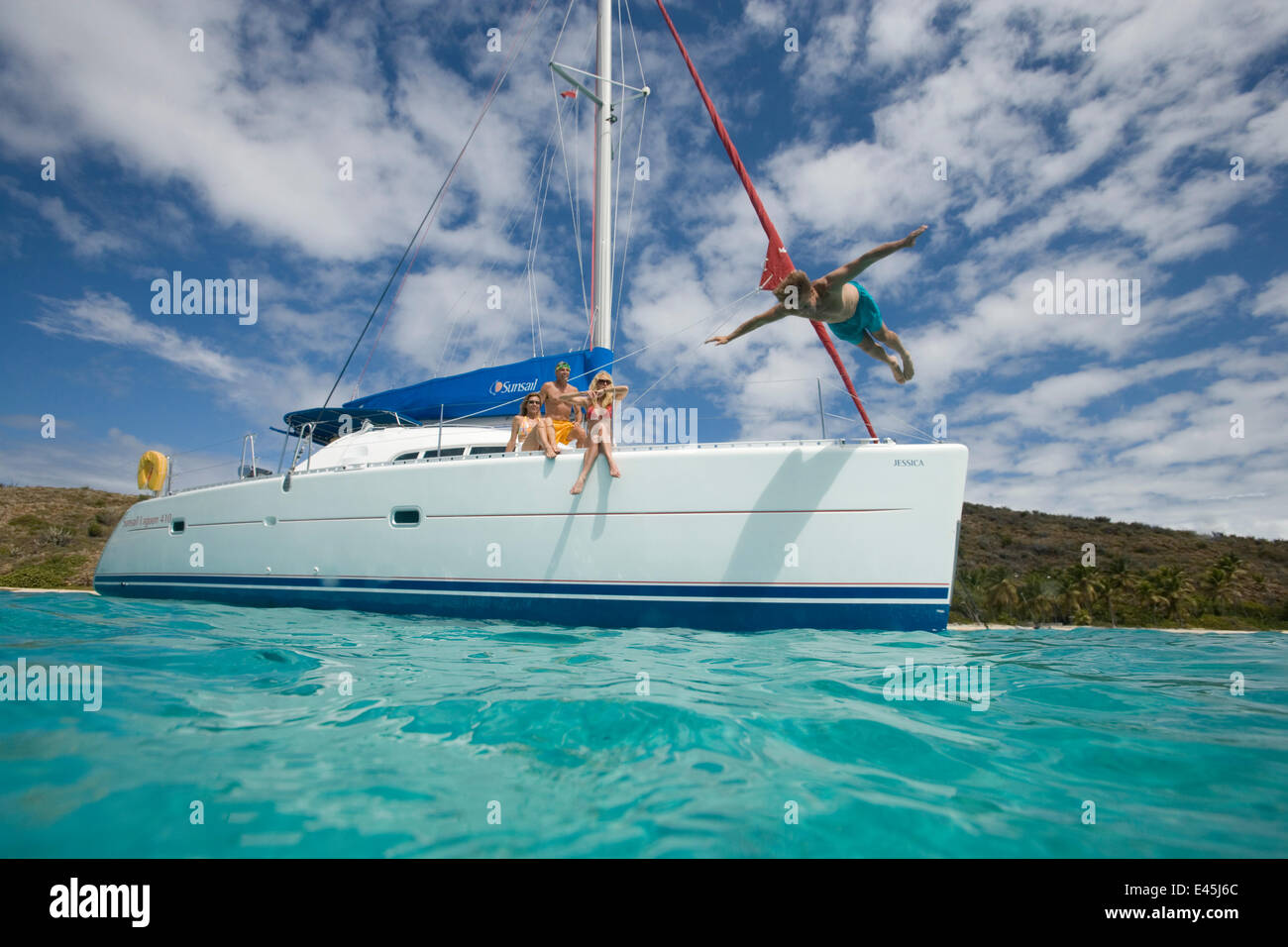 Plongée l'homme au large de la proue d'un Sunsail Lagoon 410 ancrée dans le BVI. Avril 2006, le modèle et les biens libérés. Banque D'Images