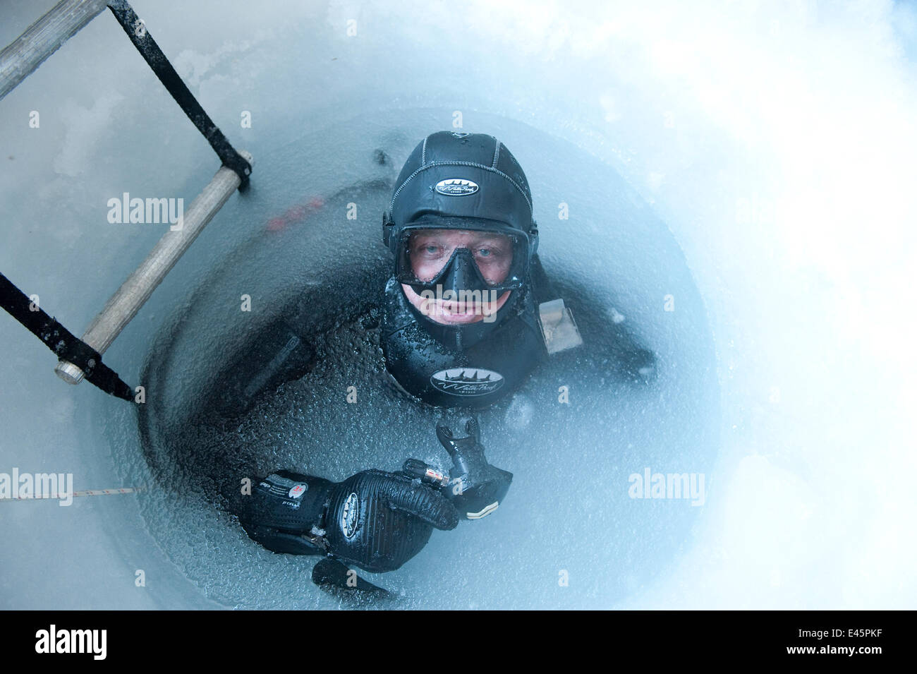 Camerman Doug Allan à la surface de l'eau gelé glace percés de trous, l'équipe du film de la BBC, McMurdo Sound, en mer de Ross, Antarctique, novembre 2008. Parution du modèle. Banque D'Images