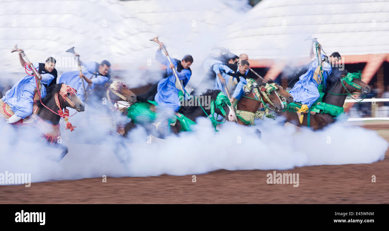 Habillé traditionnellement guerriers berbères, montés sur des chevaux arabes et Barb Barb, au galop dans la bataille de tirer vers le bas pendant la Fantasia à Dar Es Salam, Maroc, juin 2010 Banque D'Images