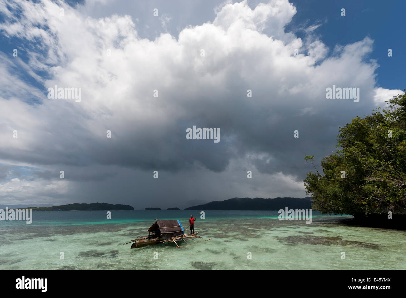 Les Papous pêcheur dans son outrigger house boat dans les eaux peu profondes sur le récif. Raja Ampat, Papouasie occidentale, en Indonésie, en février 2010 Banque D'Images