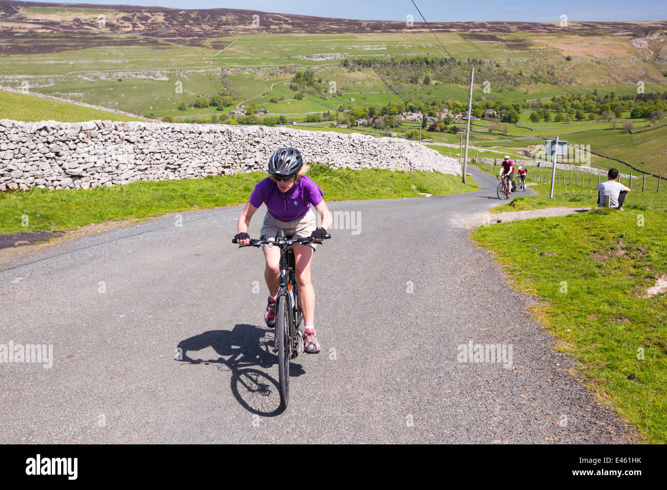 Cycliste sur une colline à grimper hors de Arncliffe dans Littondale, Yorkshire Dales, au Royaume-Uni. Banque D'Images
