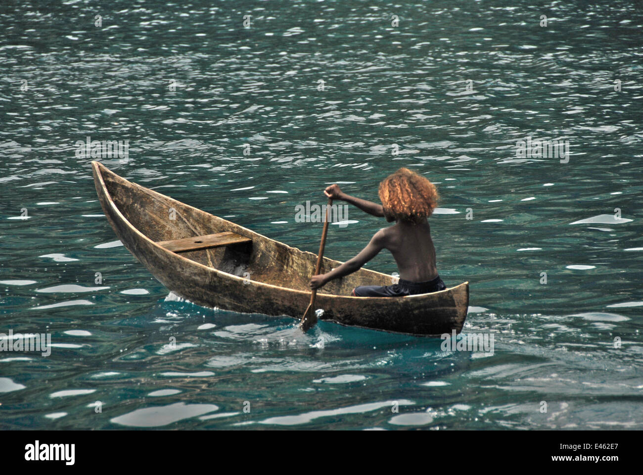 Jeune fille Peava pagaie de pirogue, village, Îles Salomon, Mélanésie, septembre 2008. Banque D'Images