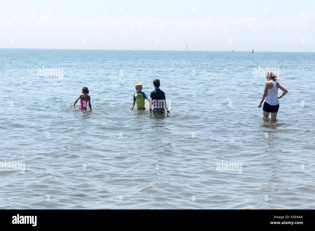 Femme avec 3 enfants de patauger dans le lac Ontario à Cherry Beach à Toronto sur une chaude journée d'été Banque D'Images