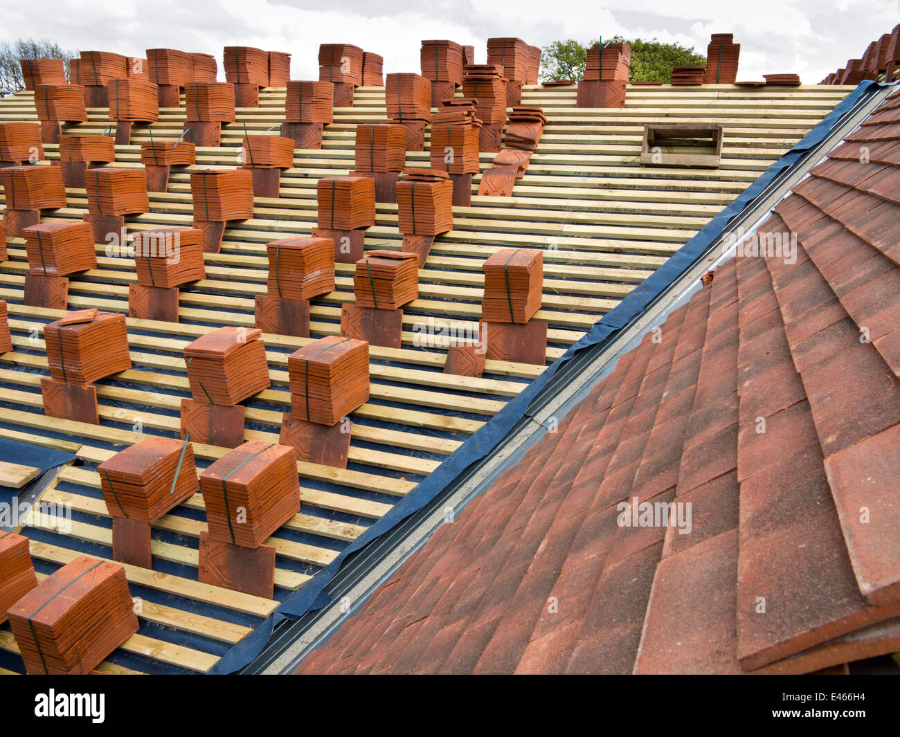 L bâtiment maison, la construction de toiture, tuiles empilées en papillotes sur voligeage prêt à être jeté Banque D'Images