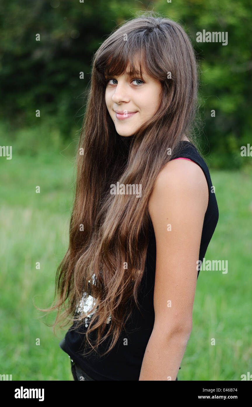 Girl Teen teenager âge transition 13 14 15 ans brunette cheveux longs nature sombre park open air magnifique portrait shirt permanent Banque D'Images